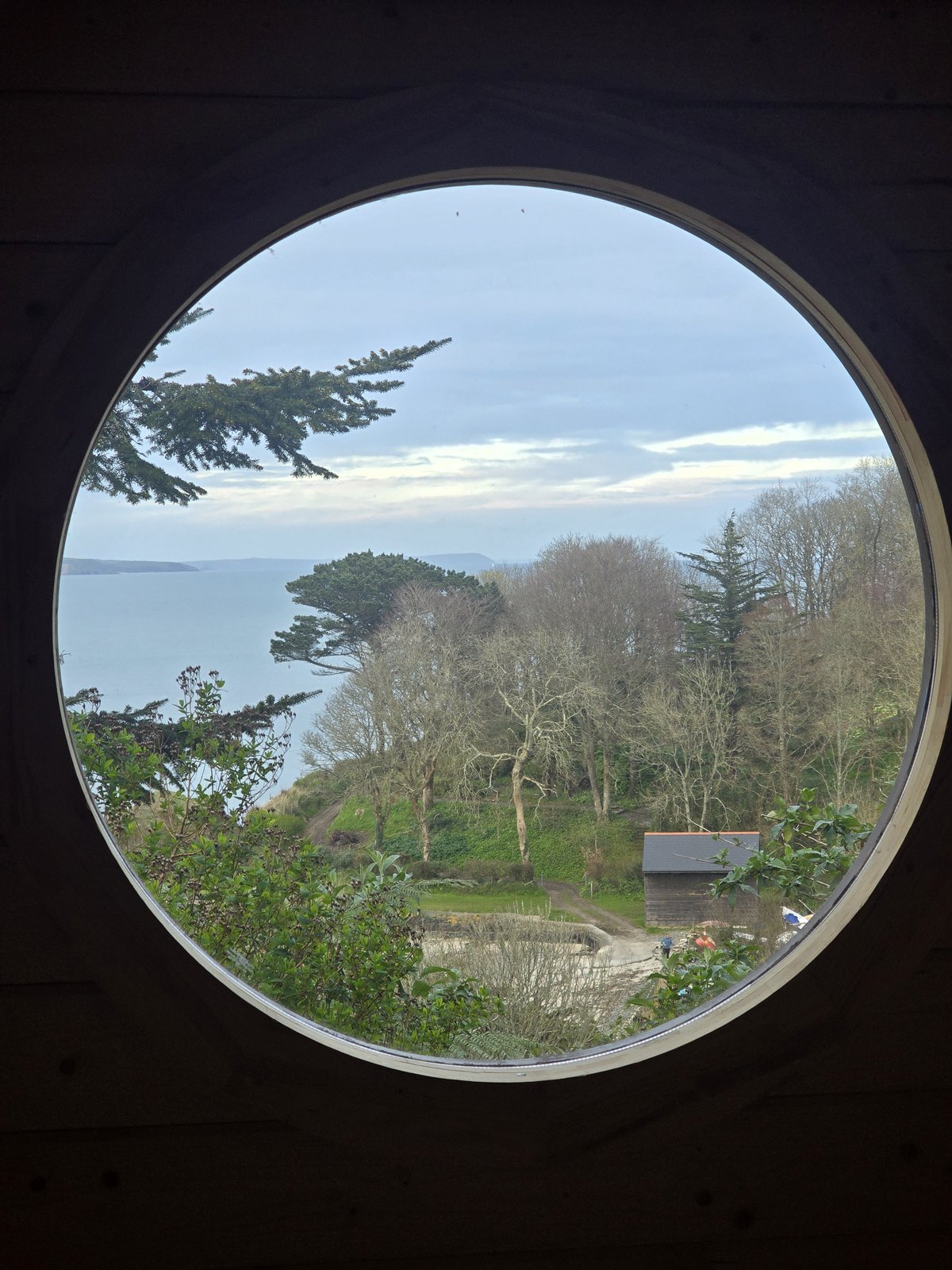 The sauna's circular window looking out to sea